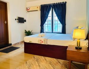 a bedroom with a large bed with a window at Sonnetta Residency in Cochin
