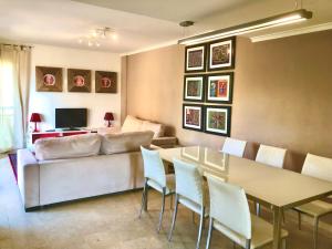 a living room with a couch and a table and chairs at Rainbow Home Coll Verd in Playa de Gandia