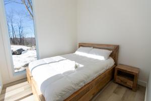 a bed in a room with a window at Chalet Luméo Private SPA, Golf & carling Lake in Brownsburg +20 photos