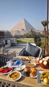 a table full of food with the pyramid in the background at garden pyramid view in Cairo