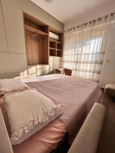 a bedroom with a large bed and a window at Boljevic Apartments in Bečići