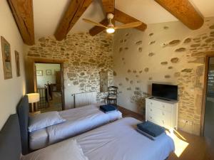 two beds in a room with a stone wall at Les Yourtes de Provence in Saint-Paulet-de-Caisson