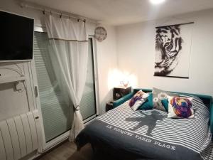 a bedroom with a blue bed and a window at Chez Lilie, Studio cosy classé 2 étoiles Plage de Stella in Cucq