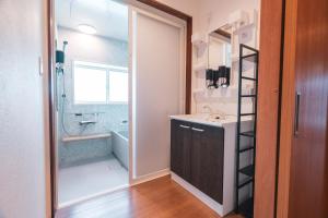 a bathroom with a sink and a shower at Myoko Yuki House in Myoko +92 photos