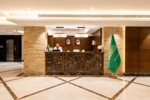 a lobby of a hotel with a man sitting at a counter at Imperial - إمبريال in Riyadh