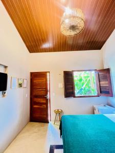a bedroom with a bed and a ceiling with a window at Recanto do cajueiro in Flecheiras