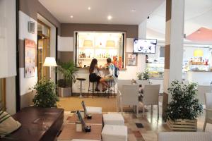 two people sitting at a bar in a restaurant at Hotel Moderno in Lido di Jesolo
