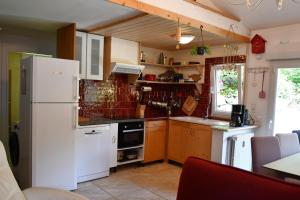 a kitchen with a white refrigerator and a stove at Gîte Le Cincle au cœur du massif des Vosges in La Bresse +5 photos
