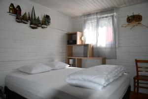 a bedroom with a bed with white sheets and a window at Gîte Le Cincle au cœur du massif des Vosges in La Bresse