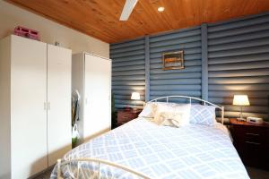 a bedroom with a bed with a blue wall at Chloes Cabin Accommodation in White Beach