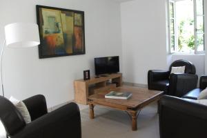 a living room with a coffee table and a tv at Gîte Les Noyers in Noailhac
