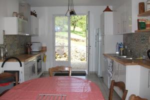 a kitchen with a table and a window in it at Gîte Les Noyers in Noailhac