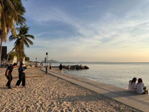 a group of people on a beach near the water at Papa House Standard Zone A in Ban Bang Saen (1)