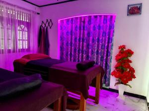 a purple room with two beds and a window at Heaven's Edge Lodge & Spa in Weligama