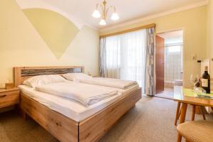 a bedroom with a large bed and a table at Kirchenwirt Durlacher in Kaibing