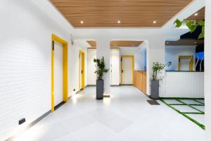 an internal hallway of a house with two plants at Stayinn Suites in Bhopal +61 photos