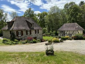 a stone house with a garden in the yard at Le moulin in Nexon