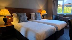 a hotel room with two beds and a window at Windmill Village Hotel, Golf Club & Spa, BW Signature Collection in Coventry