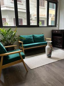 a living room with a green couch and a vase at April twelve in Hanoi