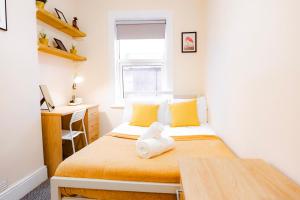 a small bedroom with a bed and a desk at Gloucester 5 Bedroom Cosy Home-Work or Leisure in Gloucestershire