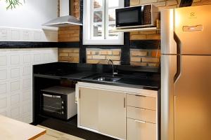 a kitchen with a refrigerator and a microwave at Casa Enxaimel em Pomerode SC 01 in Pomerode