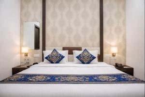 a bedroom with a large bed with blue and white pillows at Hotel Tamanna 2 Minute Walk from Golden Temple in Amritsar +10 photos