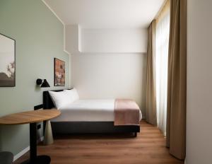 a hotel room with a bed and a table at Limehome Athens Agora in Athens