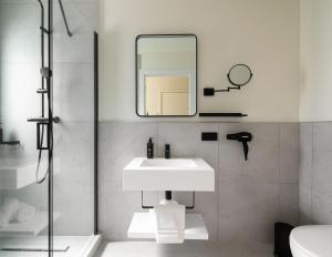 a white bathroom with a sink and a mirror at Limehome Athens Agora in Athens