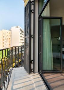 a balcony with glass doors on a building at Limehome Athens Agora in Athens +41 photos