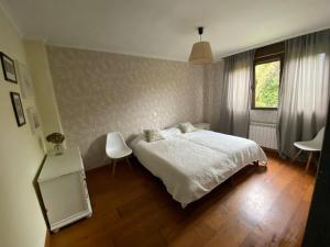 a bedroom with a bed and two chairs and a window at La Venta in Arguedes