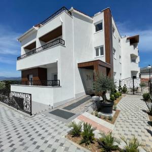 a white house with a balcony and a courtyard at lo͝or luxury retreat in Split