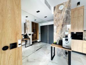 a kitchen with glass walls and a counter with a microwave at Apartament - Vidok 301 in Olsztyn