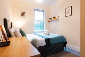 a small bedroom with a bed and a window at Gloucester 5 Bedroom Cosy Home-Work or Leisure in Gloucestershire +11 photos