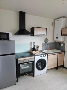 a kitchen with a washing machine and a dishwasher at Appartement T2 in Le Creusot