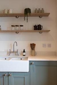 a kitchen with blue cabinets and a sink at Luxury Farmhouse, near Dornoch in The Mound