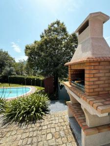 a brick oven sitting next to a swimming pool at Casa das Castanhas - Cinfães, Viseu in Cinfães +98 photos