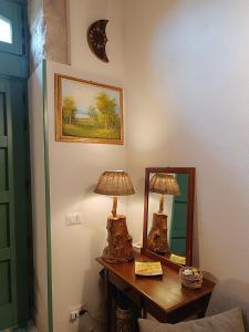 a room with a table with a lamp and a mirror at Casetta Santa Venera in Modica +39 photos