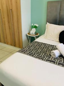 a bedroom with a bed and a side table at The blyde-Luxury one bedroom apartment in Pretoria