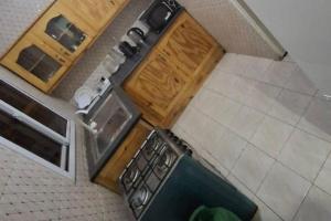 an overhead view of a kitchen with wooden cabinets at Inviting 1-Bed House in Brusubi in Brusubi +10 photos