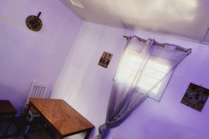 a room with a window with a curtain and a table at Inviting 1-Bed House in Brusubi in Brusubi