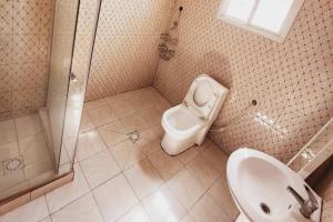 a bathroom with a sink and a toilet and a shower at Inviting 1-Bed House in Brusubi in Brusubi
