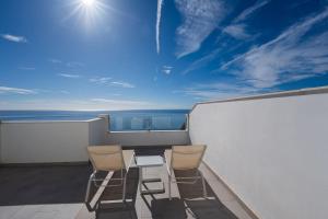 a balcony with two chairs and a view of the ocean at Terrazas de Ladera Duplex 7 Casasol in Nerja