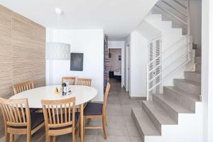 a dining room with a table and chairs and a staircase at Terrazas de Ladera Duplex 7 Casasol in Nerja +39 photos