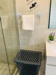 a shower with a black basket in a bathroom at The blyde-Luxury one bedroom apartment in Pretoria +16 photos