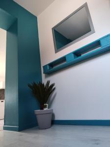 a tv on a wall with a potted plant at Le gîte des hallais in Bouelles +20 photos