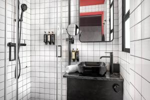 a bathroom with a sink and a shower with a mirror at Max Brown Hotel Downtown Part of Sircle Collection Formally known as Dave Red in Athens +35 photos