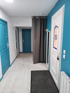 an empty hallway with blue walls and blue doors at Le gîte des hallais in Bouelles