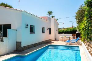 a villa with a swimming pool next to a house at Villa Margarita Punta Prima by Escape Home in Punta Prima