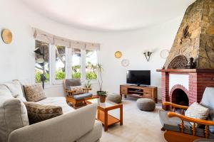 a living room with a couch and a fireplace at Villa Margarita Punta Prima by Escape Home in Punta Prima