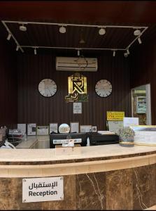 a store with clocks on the wall and a counter at رندة المدن للشقق المخدومة in Jazan